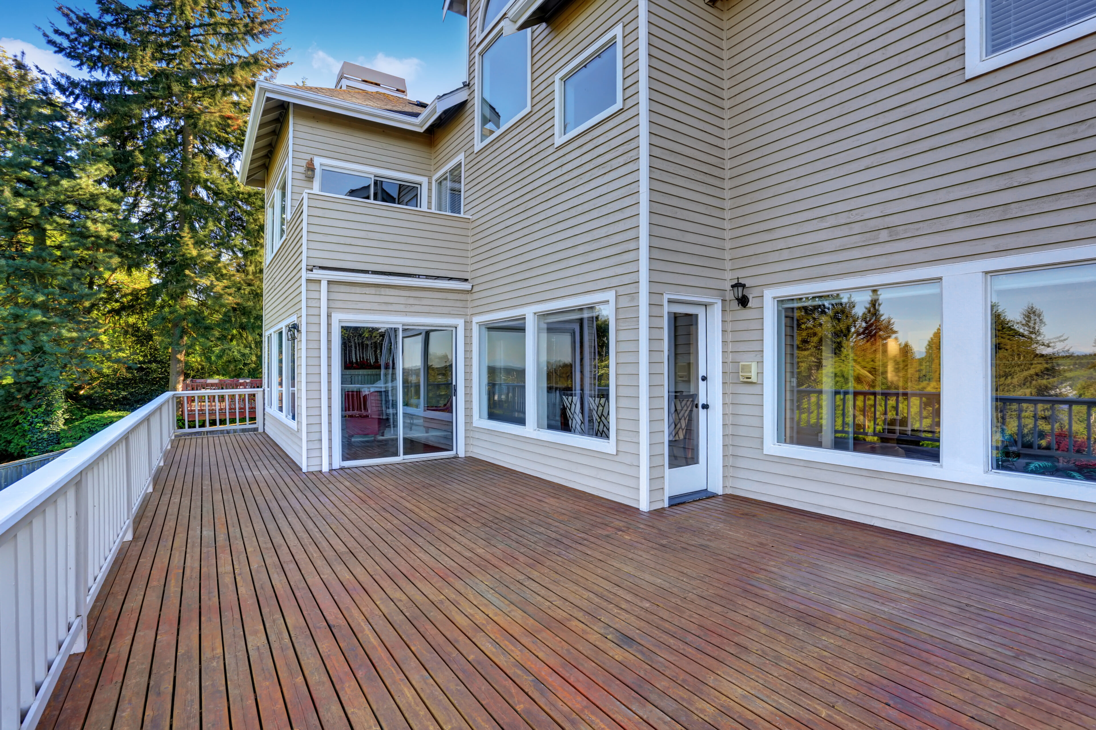 Spacious wooden deck attached to modern house.