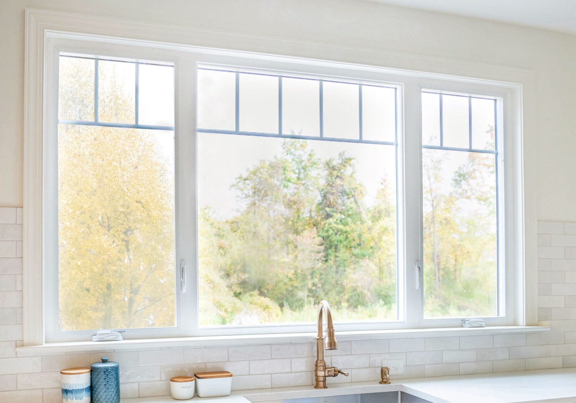 A kitchen with three windows and a sink