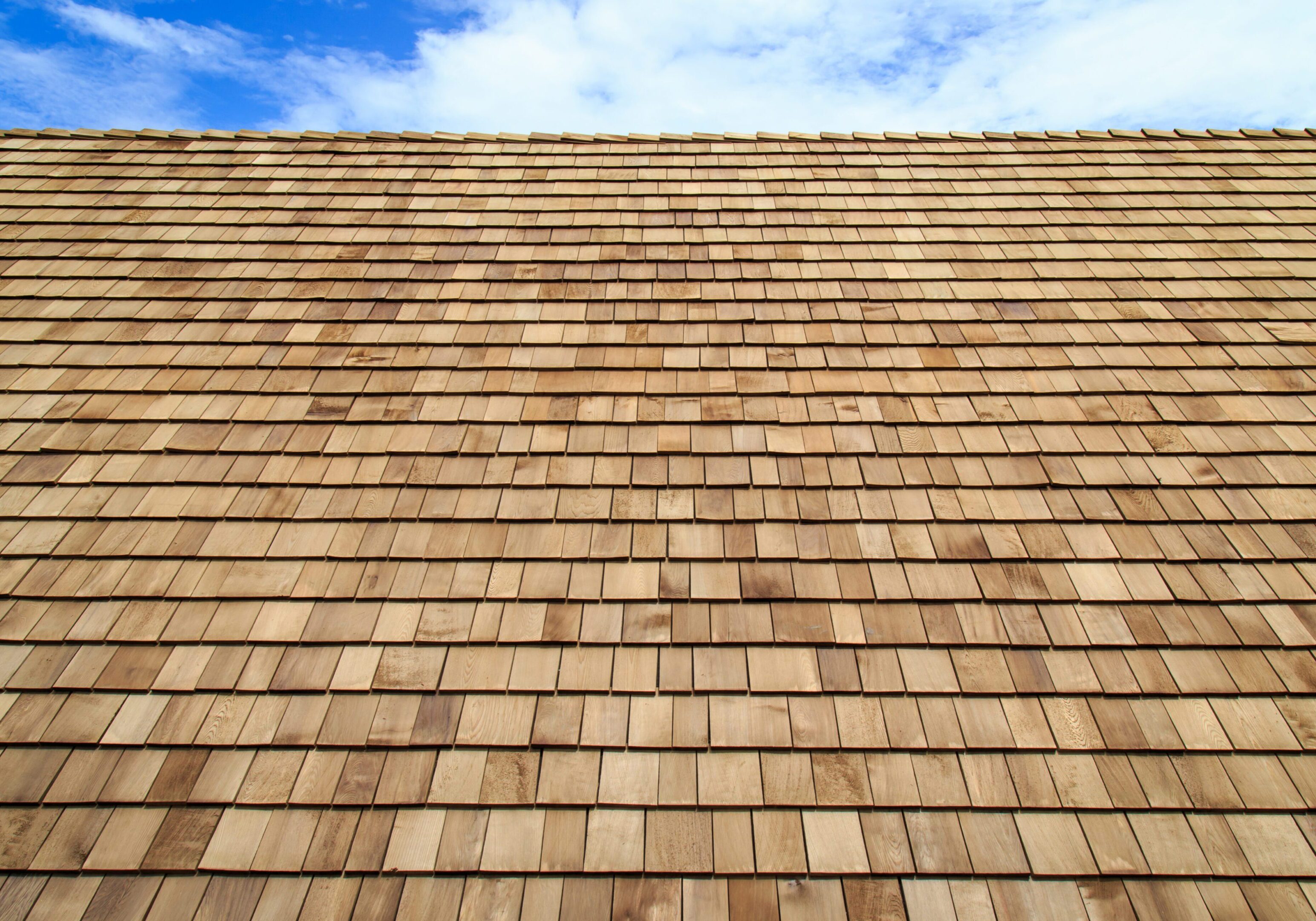 Wooden roof Shingle texture Wooden shingles roof under blue sky.