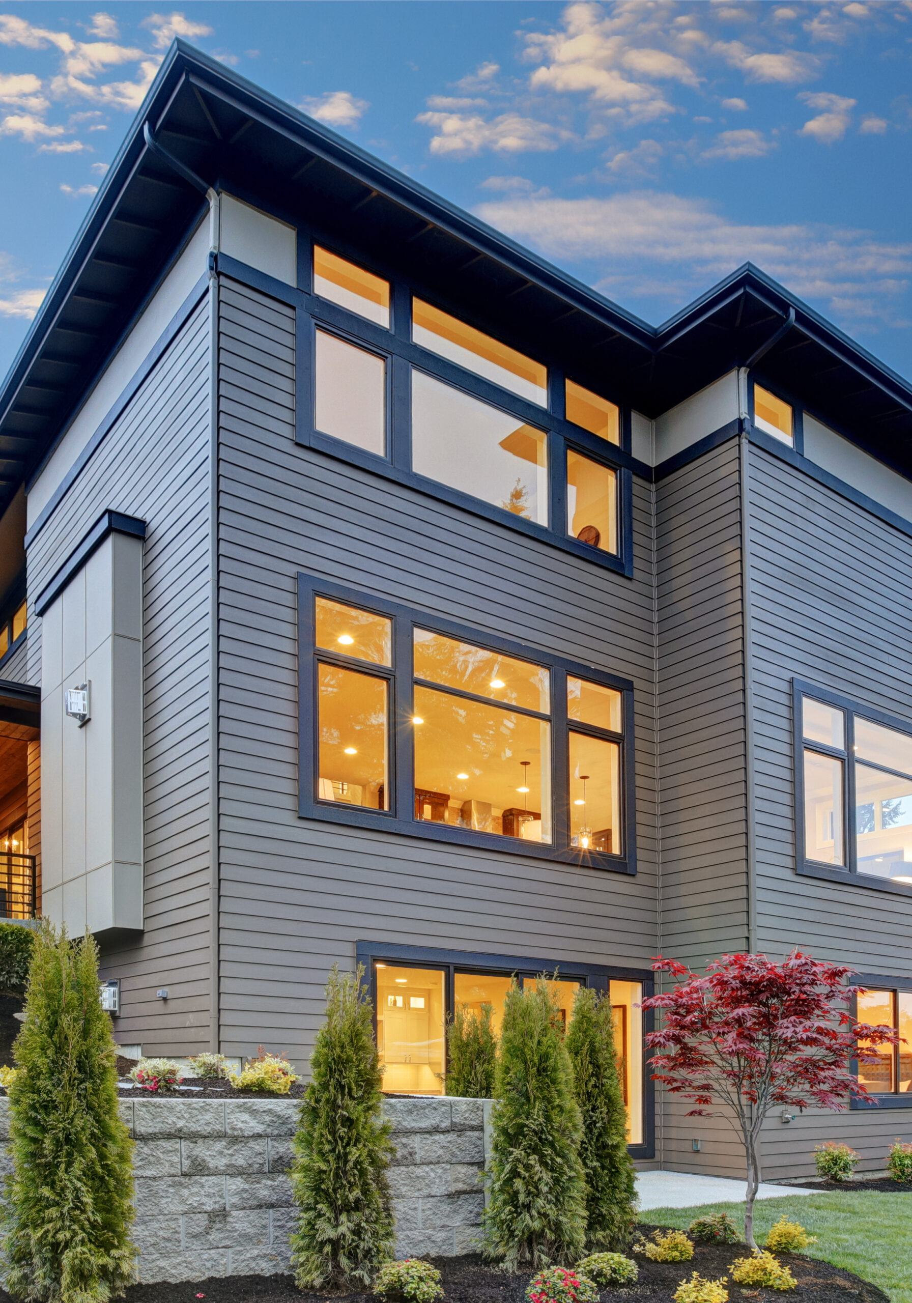 Modern house with large windows and garden.