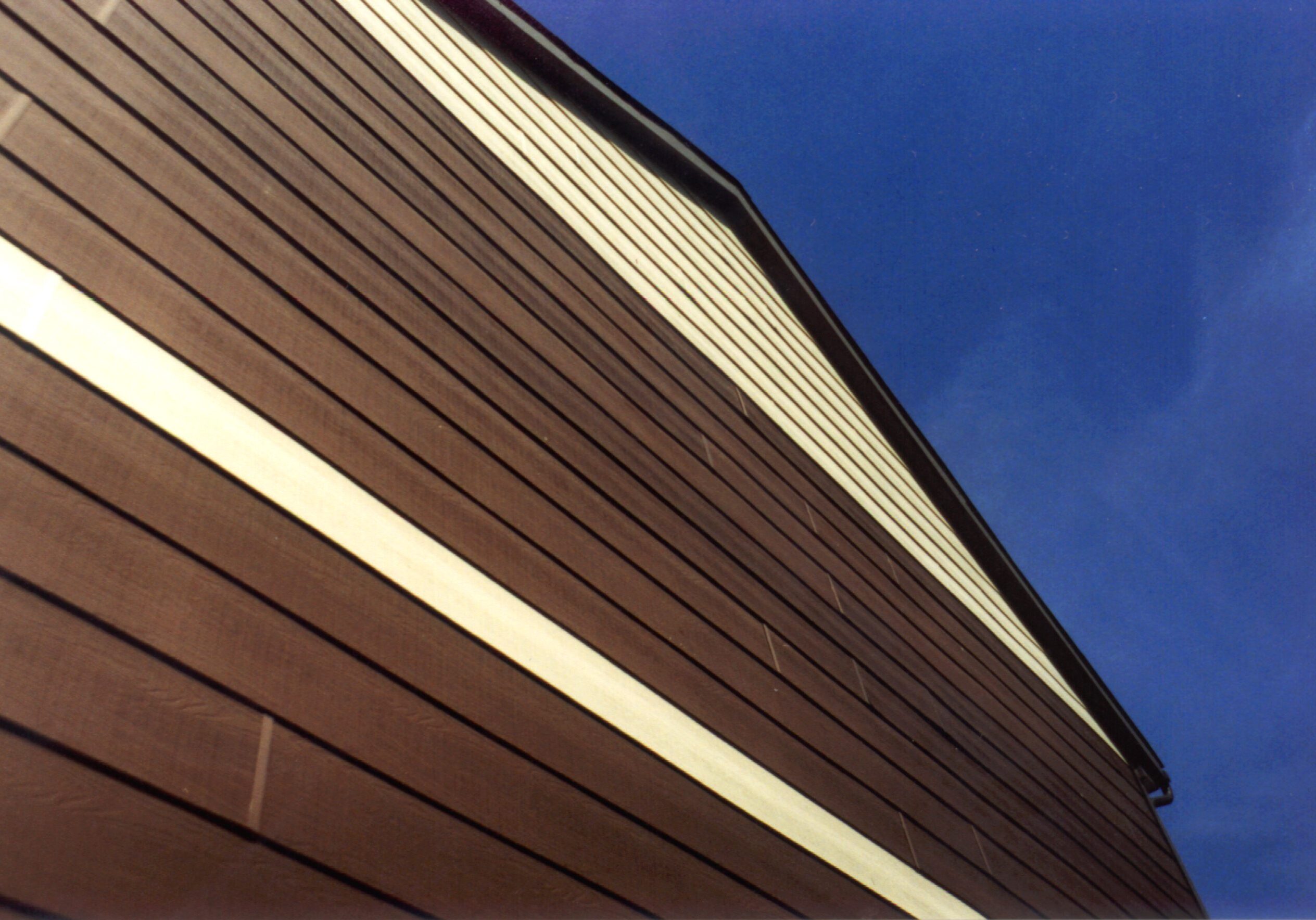 Where are the Windows? Brown building siding against clear blue sky.